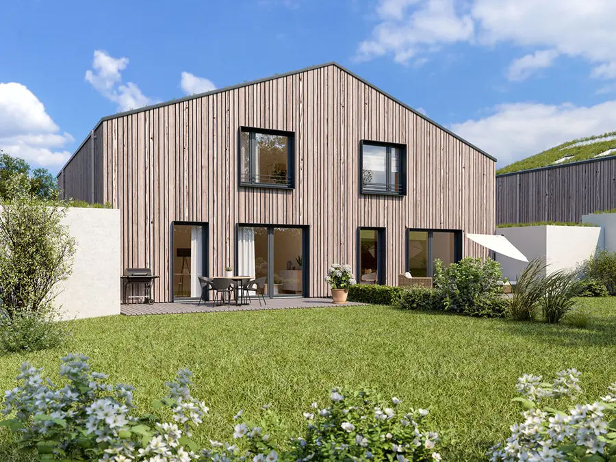 Modernes Holzhaus mit Terrasse, Garten und großen Glasfronten im sonnigen Außenbereich.