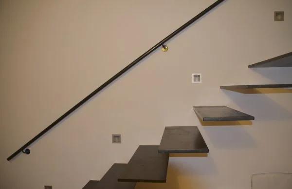 Moderne Kragarmtreppe im sanierten 60er-Jahre-KfW-Haus mit minimalistischem Design.