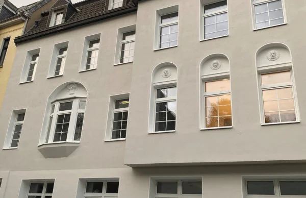 Gepflegte Wohnhausfassade am Christbusch 26 mit weißen Fenstern und Dachgauben.