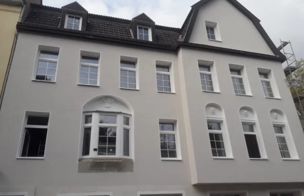 Sanierte Altbau-Fassade mit Sprossenfenstern und Dachgauben am Christbusch.