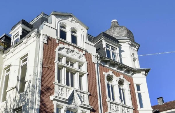 Denkmalgerechte Sanierung eines historischen Wohnhauses mit reich verzierter Backsteinfassade und Turm.