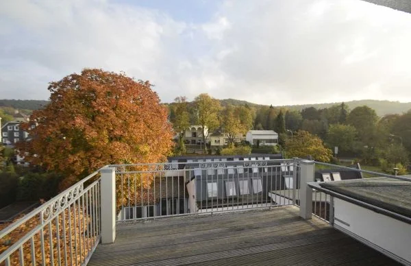 Ausblick von der ehemaligen Verwaltungs-Villa Herberts auf herbstliche Dächer und grüne Hügel.