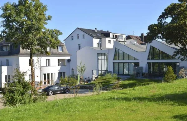 Ehemalige Verwaltungs-Villa Herberts mit moderner weißer Architektur und gepflegtem Garten.