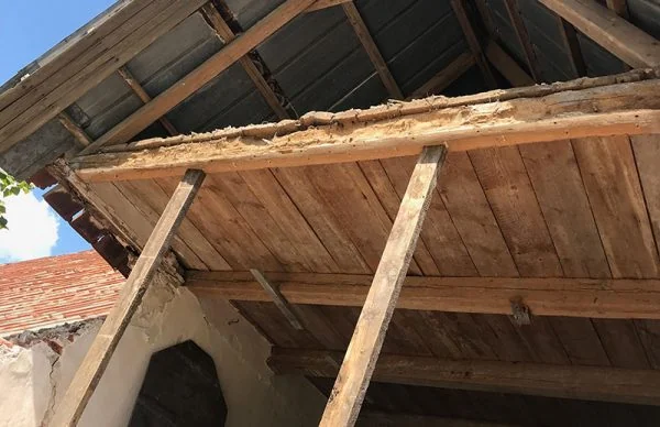 Rustikales Holzdach der Ferienanlage Katharinenhof mit alten Balken und Stützpfosten.