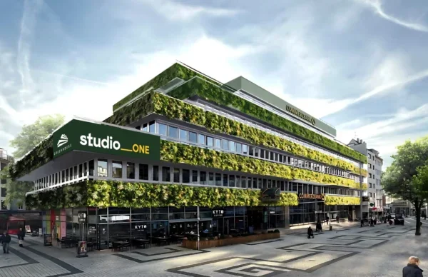 Greenhouse am Neumarkt mit begrünter Fassade, Café und modernem Stadtplatz.