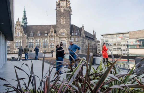 Dachterrasse am Neumarkt mit Stadtblick auf historischen Uhrturm.