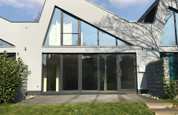 Moderne Loft-Fassade mit Glasfront, Satteldach und Terrasse im minimalistischen Wohnhaus.