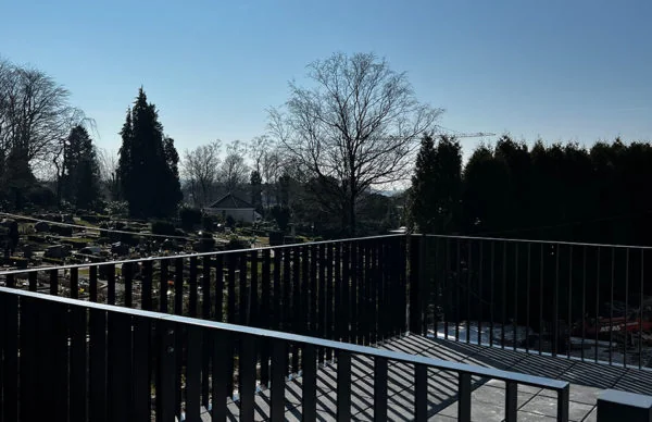 Balkonblick der Lofts in Ronsdorf auf gepflegten Friedhof und grüne Anlage.