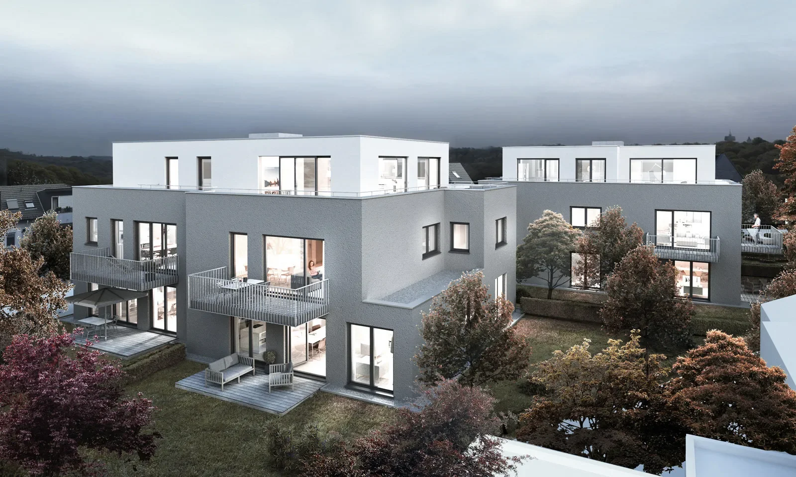Moderne Wohnanlage Lohbuschpark mit Balkonen, Dachterrassen und begrüntem Innenhof bei Dämmerung.