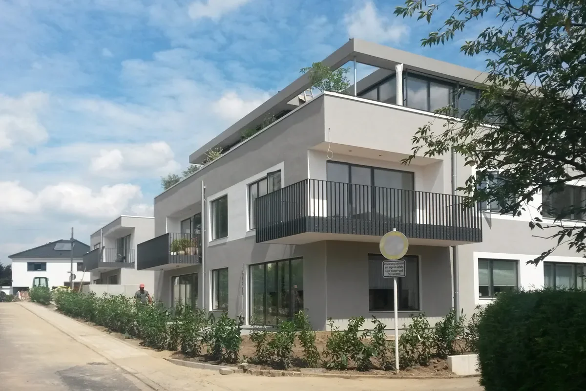 Modernes Mehrfamilienhaus am Rübezahlweg mit Balkonen, Dachterrasse und Neubau-Wohnumfeld.