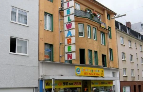 Geschäftshaus Luisenstraße 25 mit Spielwarenladen und Wohnungen in urbaner Straßenfassade.