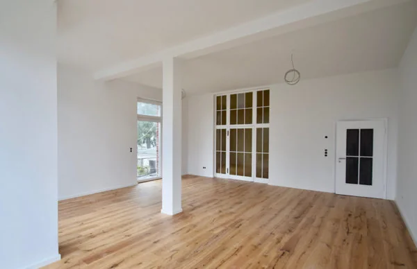 Heller renovierter Wohnraum mit Holzboden und Glasfront in der Oberen Lichtenplatzer Straße.