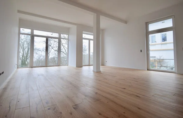 Heller Wohnraum mit Eichenparkett und bodentiefen Fenstern in der Oberen Lichtenplatzer Straße.