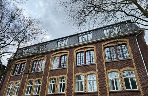 Historische Backsteinfassade mit Rundbogenfenstern und Mansarddach an der Schönen Aussicht.