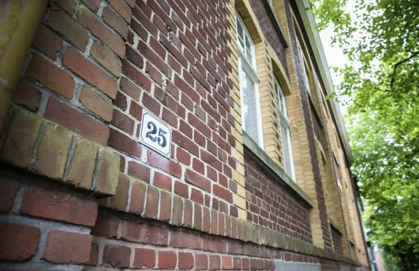 Backsteinfassade Schöne Aussicht 25 mit Ziegeldetails und grünen Bäumen.