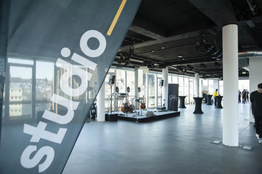 Moderne Eventlocation mit Skylineblick, Bühne, Musik-Equipment und Studio-Atmosphäre.