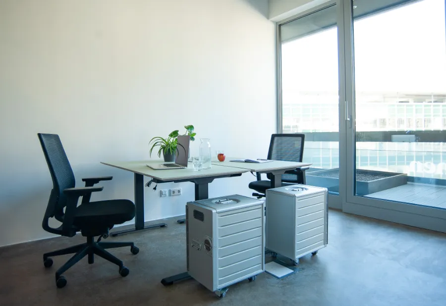 Moderner Büroarbeitsplatz mit Schreibtisch, ergonomischen Stühlen, Glastür und minimalistischem Design.