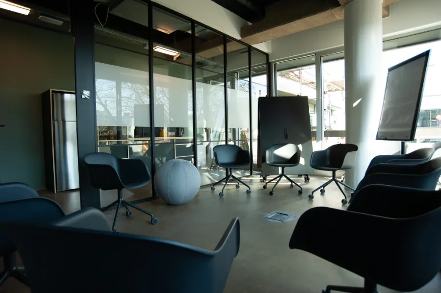 Moderner Meetingraum mit Stuhlkreis, Flipchart und flexibler Workshop-Ausstattung.